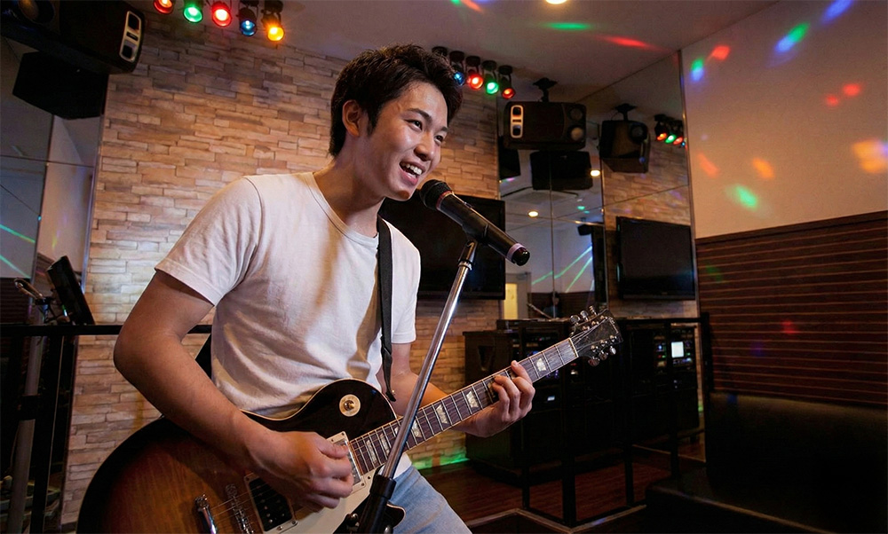 ギターを弾きながら歌を練習している男性